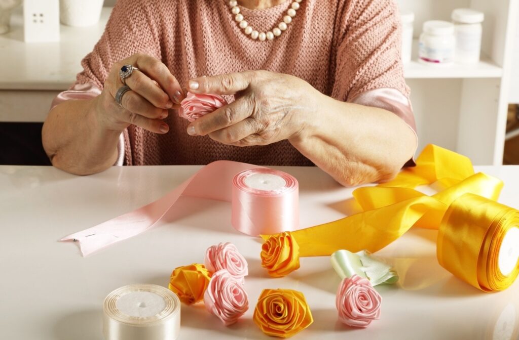 A senior making roses out of ribbon