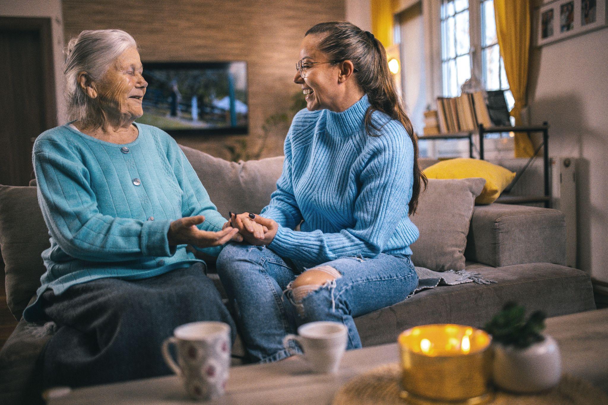An older adult and elderly person talking to each other over a cup of tea